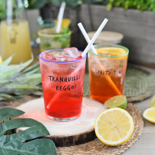 Bicchiere Egan Smile “Tranquilli, Reggo!” ambientato su tavola con drink e ghiaccio